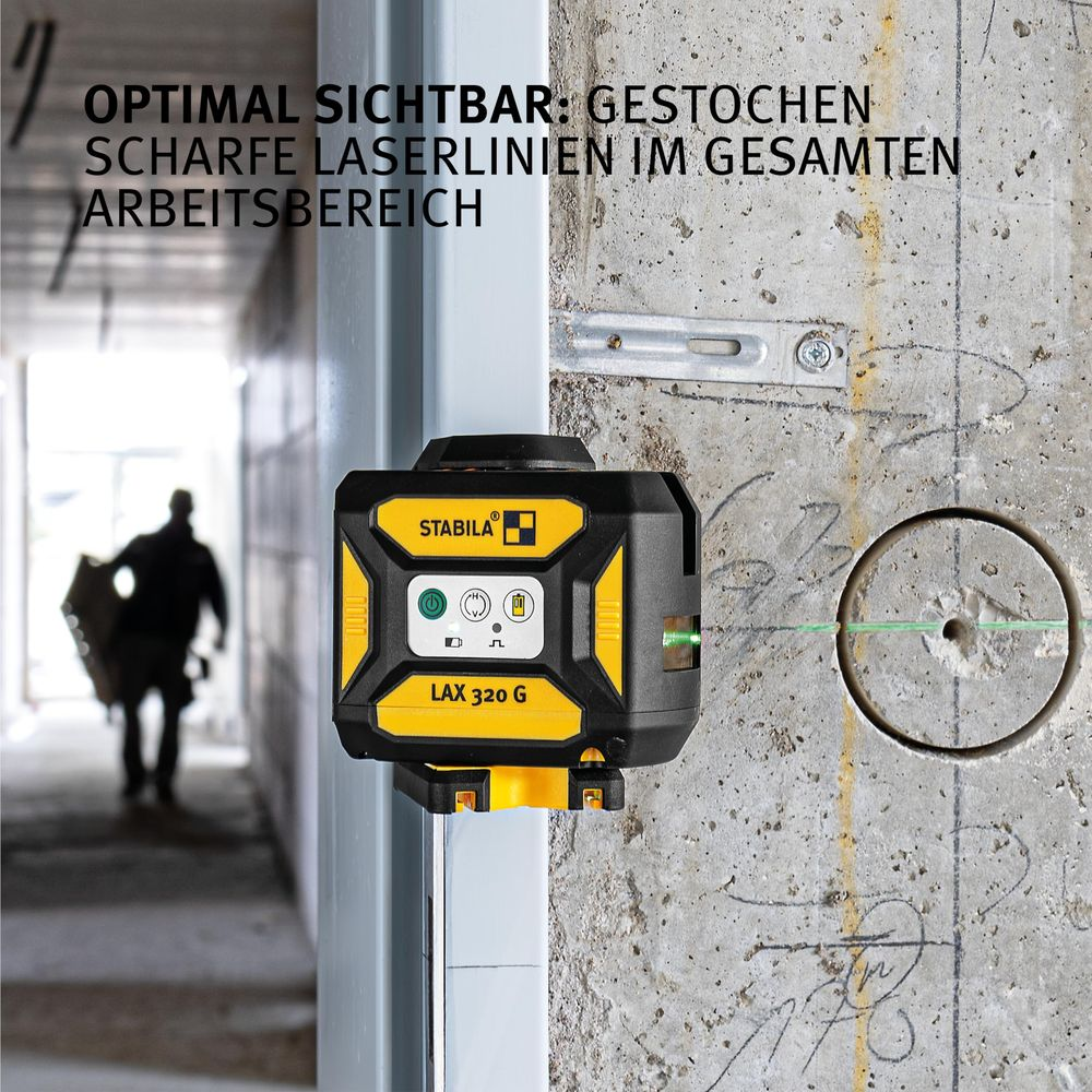 Un niveau laser jaune avec des lignes laser vertes sur un mur de béton.