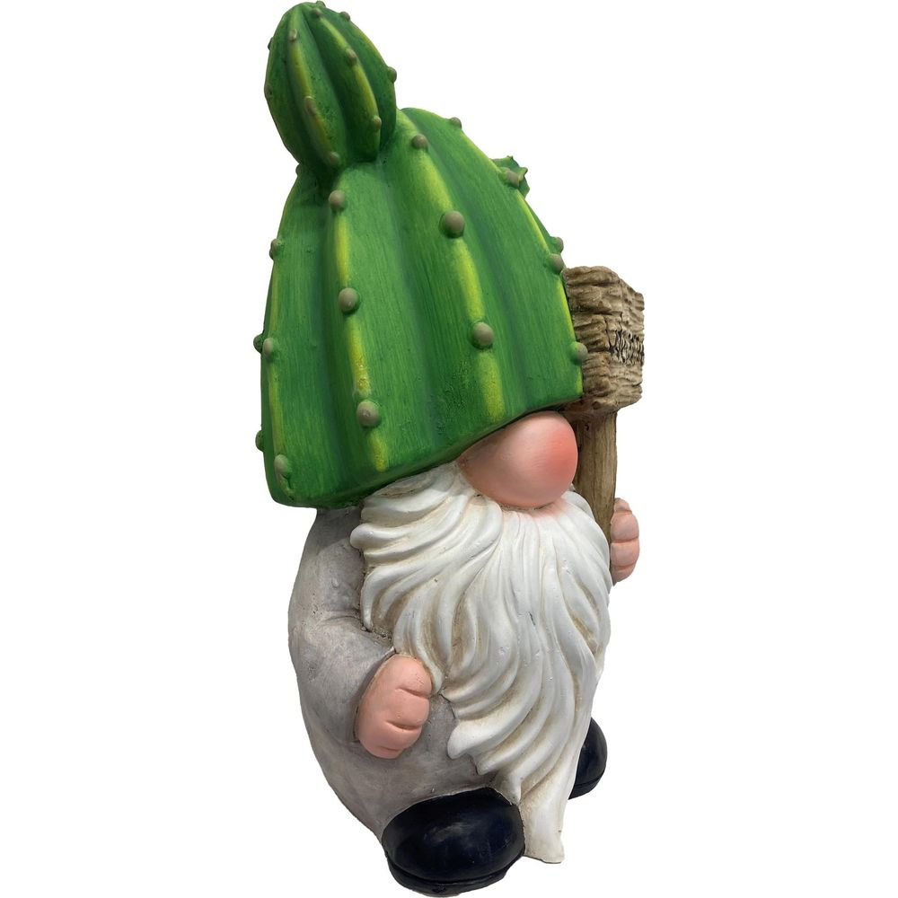 Eine Gartenzwergfigur mit einem grünen Kaktushut und weißem Bart, die ein Schild hält.