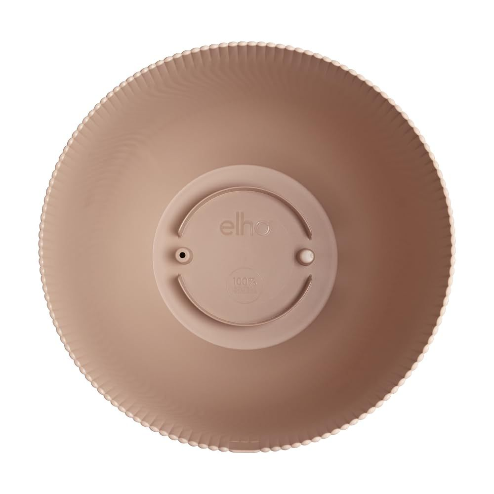 Il lato inferiore di un vaso Elho beige con bordo scanalato e rientranze circolari.