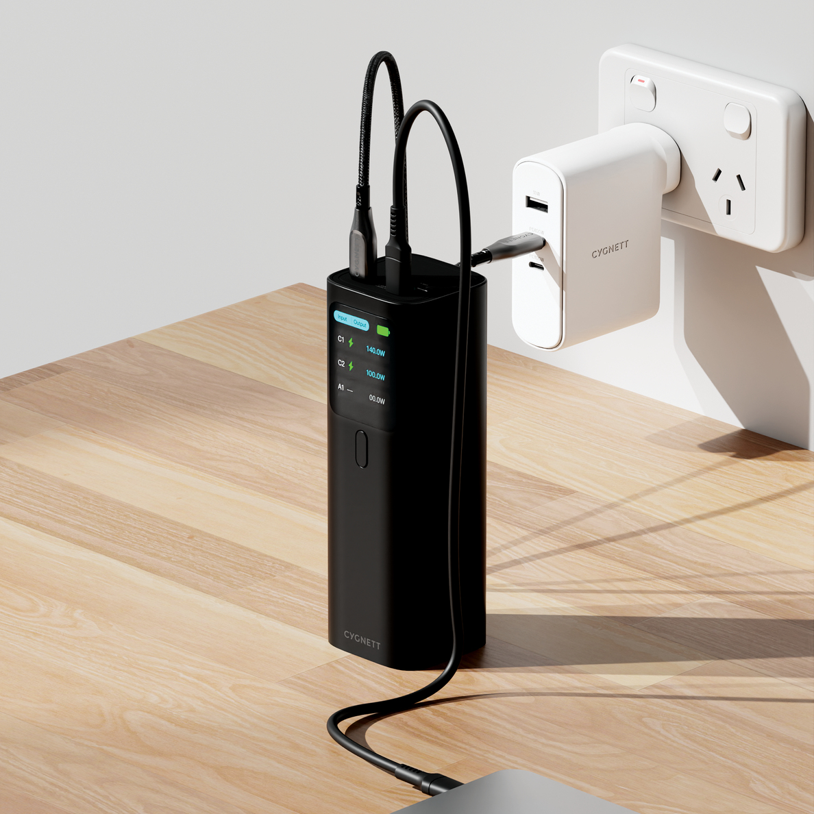 Batterie externe noire chargeant via adaptateur mural. Ports USB-C affichent puissance.