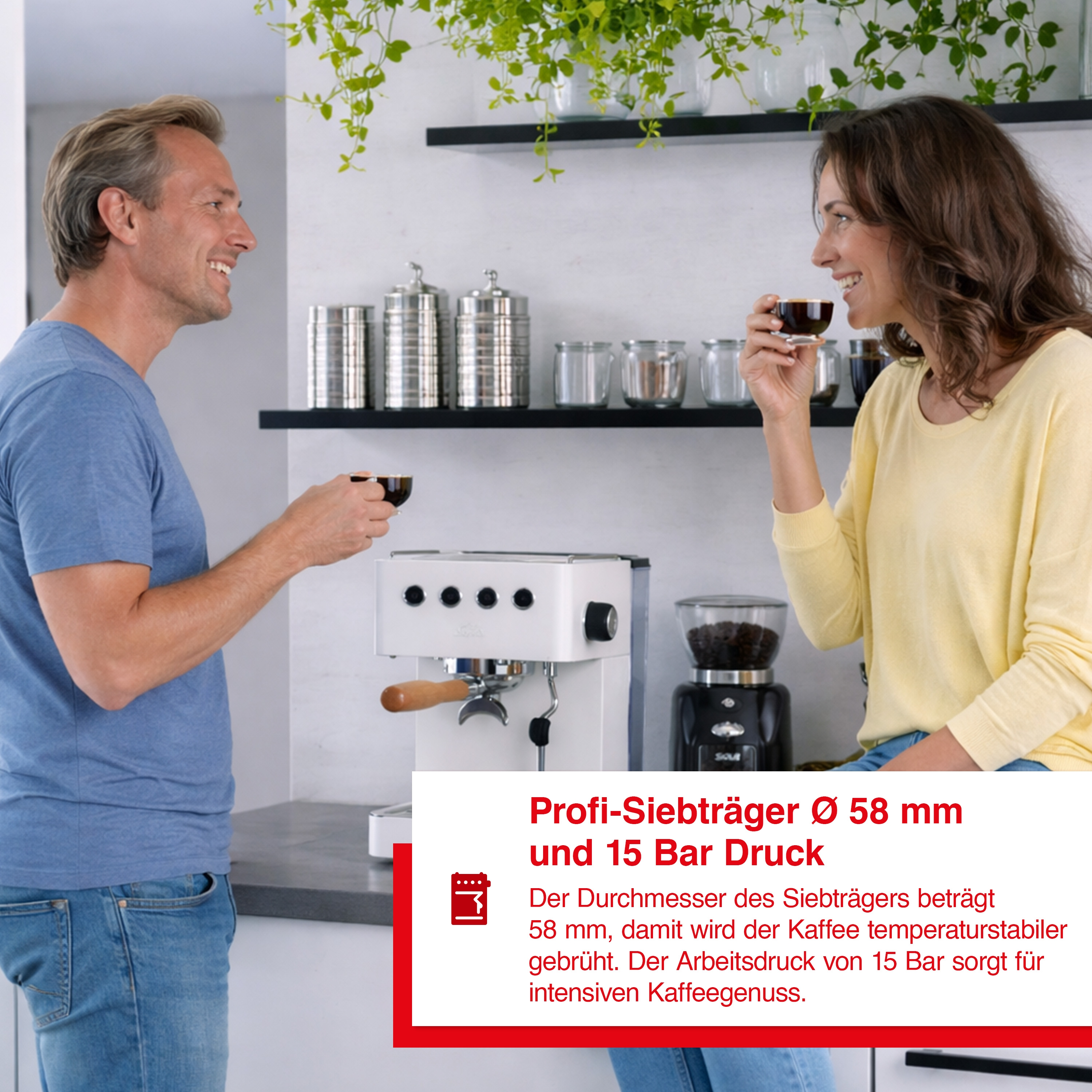 Ein Mann und eine Frau genießen Kaffee neben einer weißen Espressomaschine und Mühle.