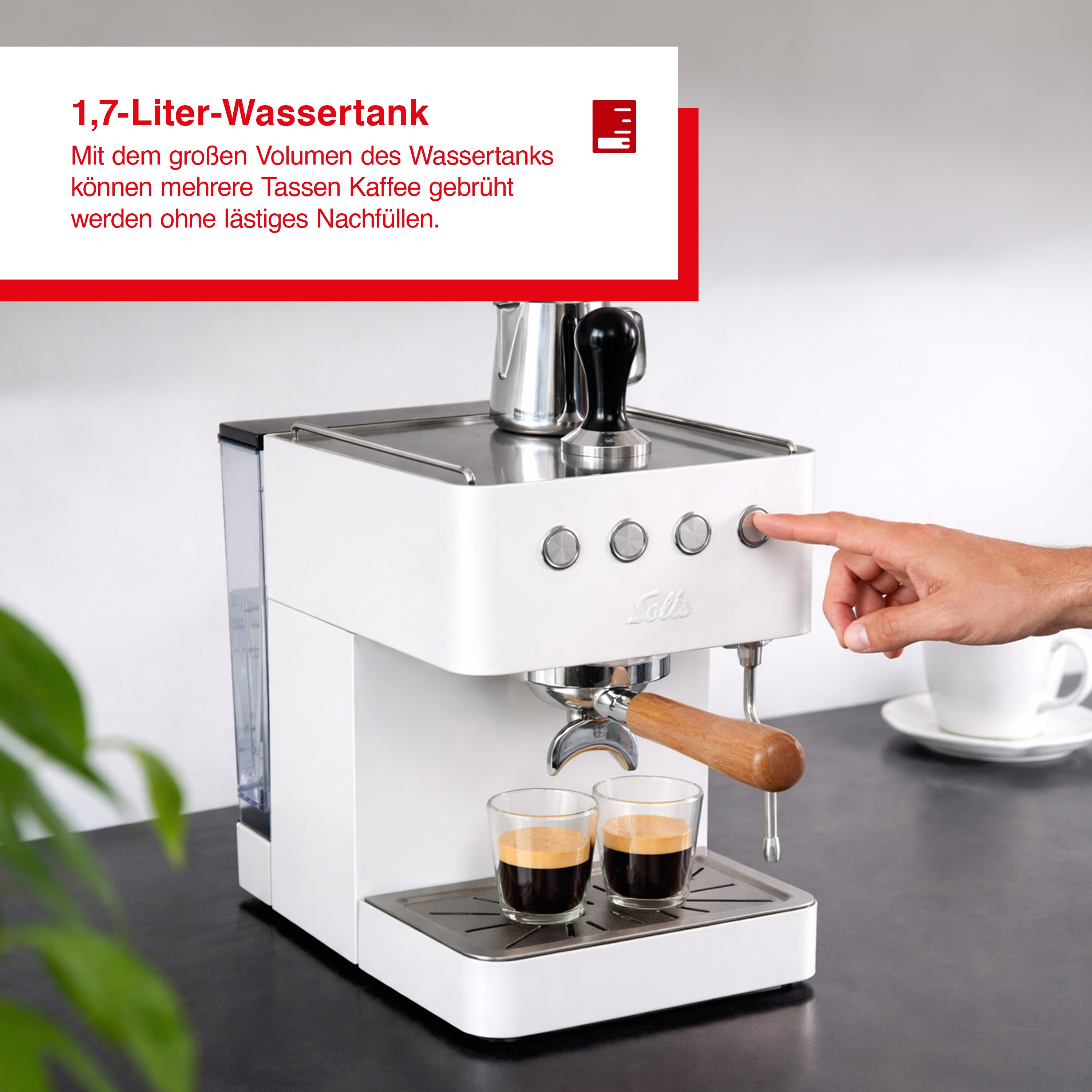Eine weiße Espressomaschine mit zwei Tassen Espresso, ein Finger drückt auf einen Knopf.