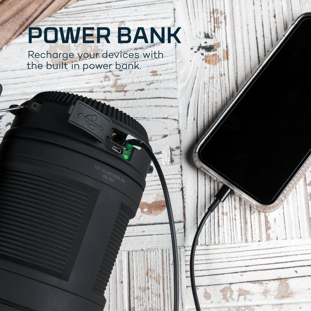 Batterie externe noire rechargeant un smartphone via câble USB.
