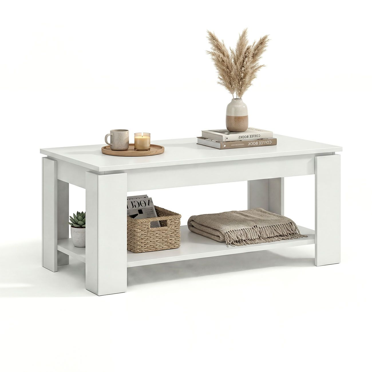 Una mesa de centro blanca de dos niveles decorada con tazas, velas, libros, un jarrón con juncos y una manta.