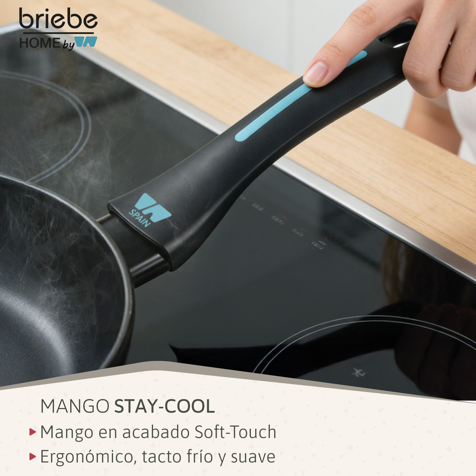 Una mano sujeta el mango de una sartén negra sobre una placa de inducción.