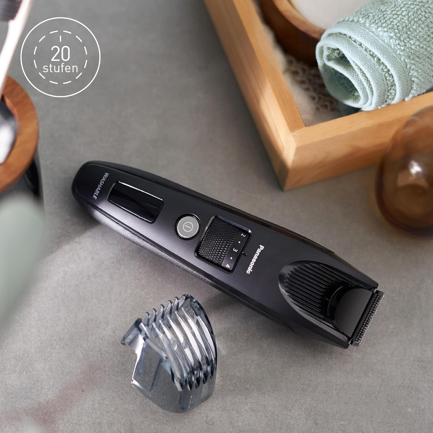 Czarny trymer Panasonic leży na szarej powierzchni, obok niego nasadka.