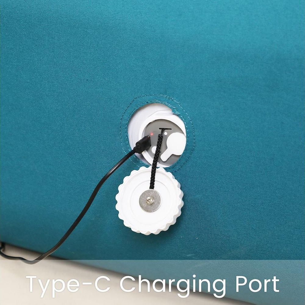 Siyah bir USB-C kablosu, beyaz bir kapağın yakınında, turkuaz bir yüzeye takılı.