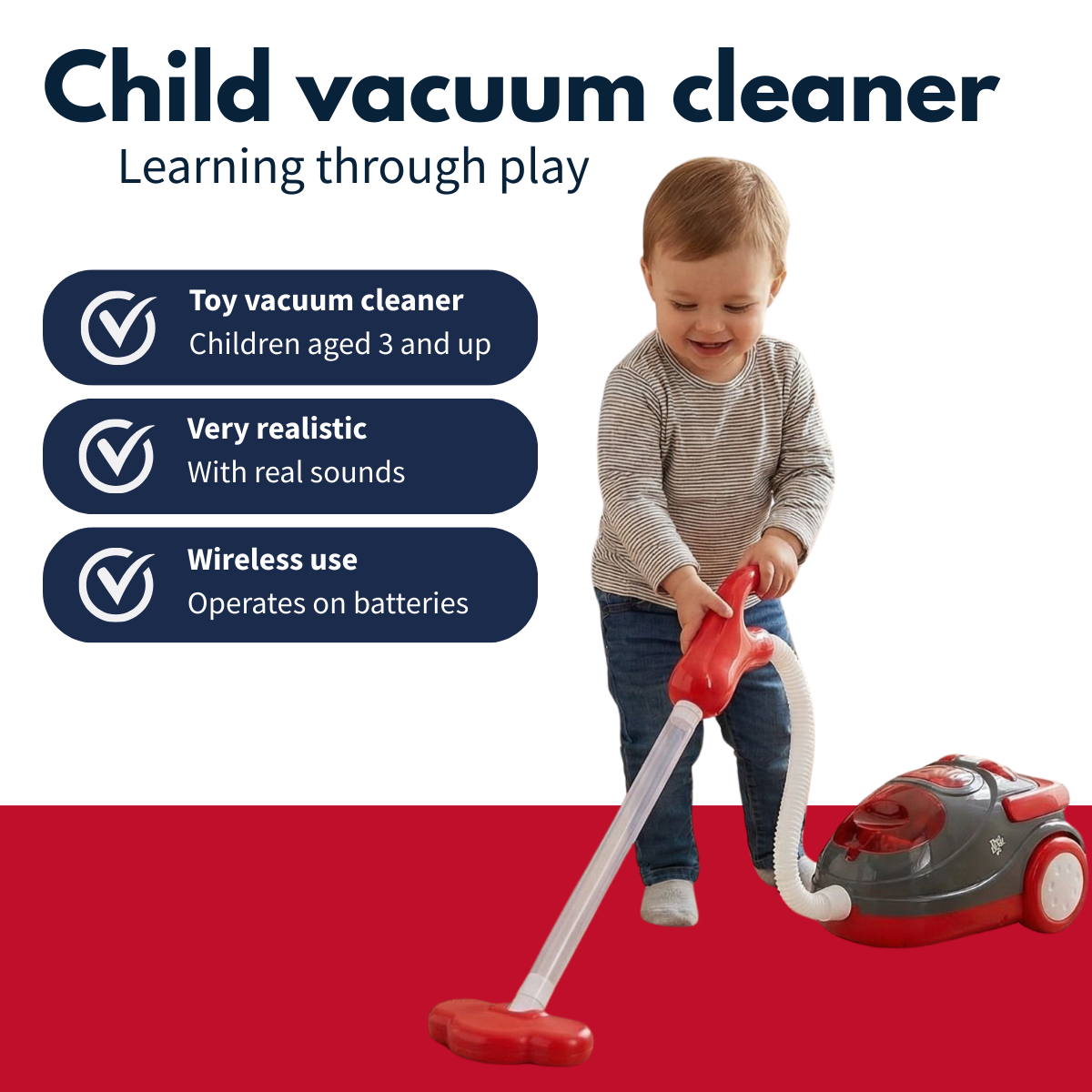 A child plays with a red and gray toy vacuum cleaner.