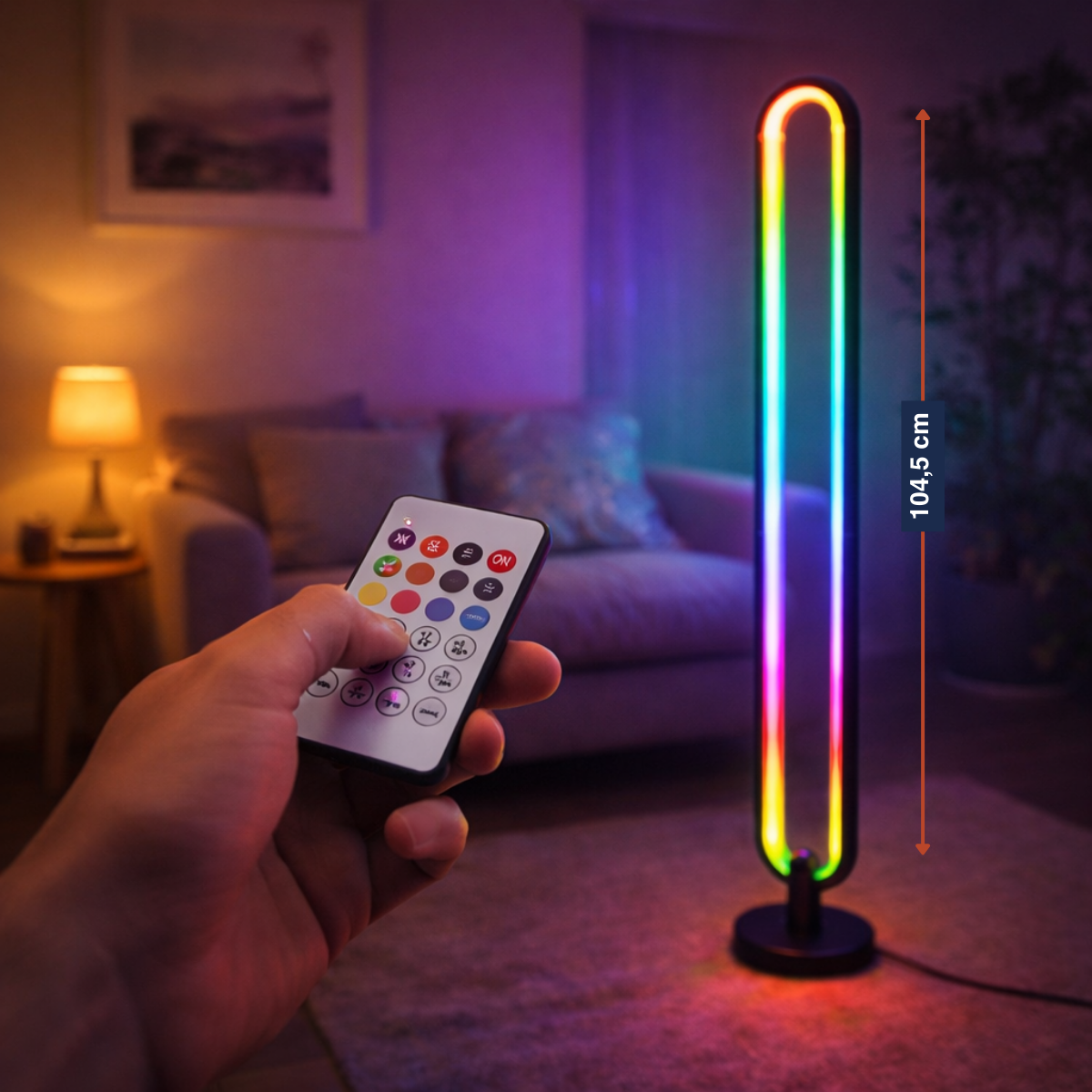 Eine Hand hält eine Fernbedienung vor einer modernen Stehlampe mit RGB-Beleuchtung.