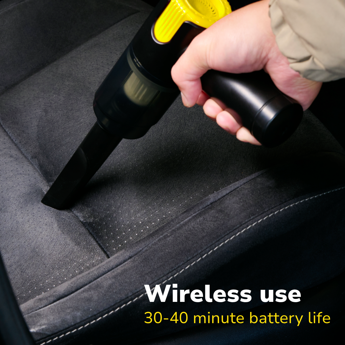Aspirateur à main nettoyant un siège de voiture sombre avec appareil noir et jaune. Texte : Utilisation sans fil 30-40 min batterie.