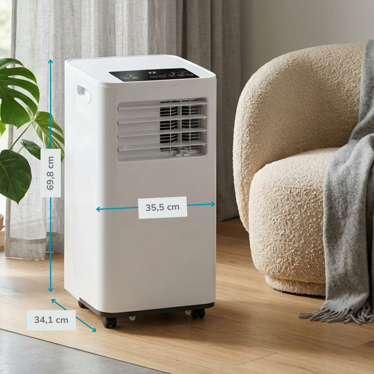 A white portable air conditioner stands next to an armchair. Dimensions are shown.