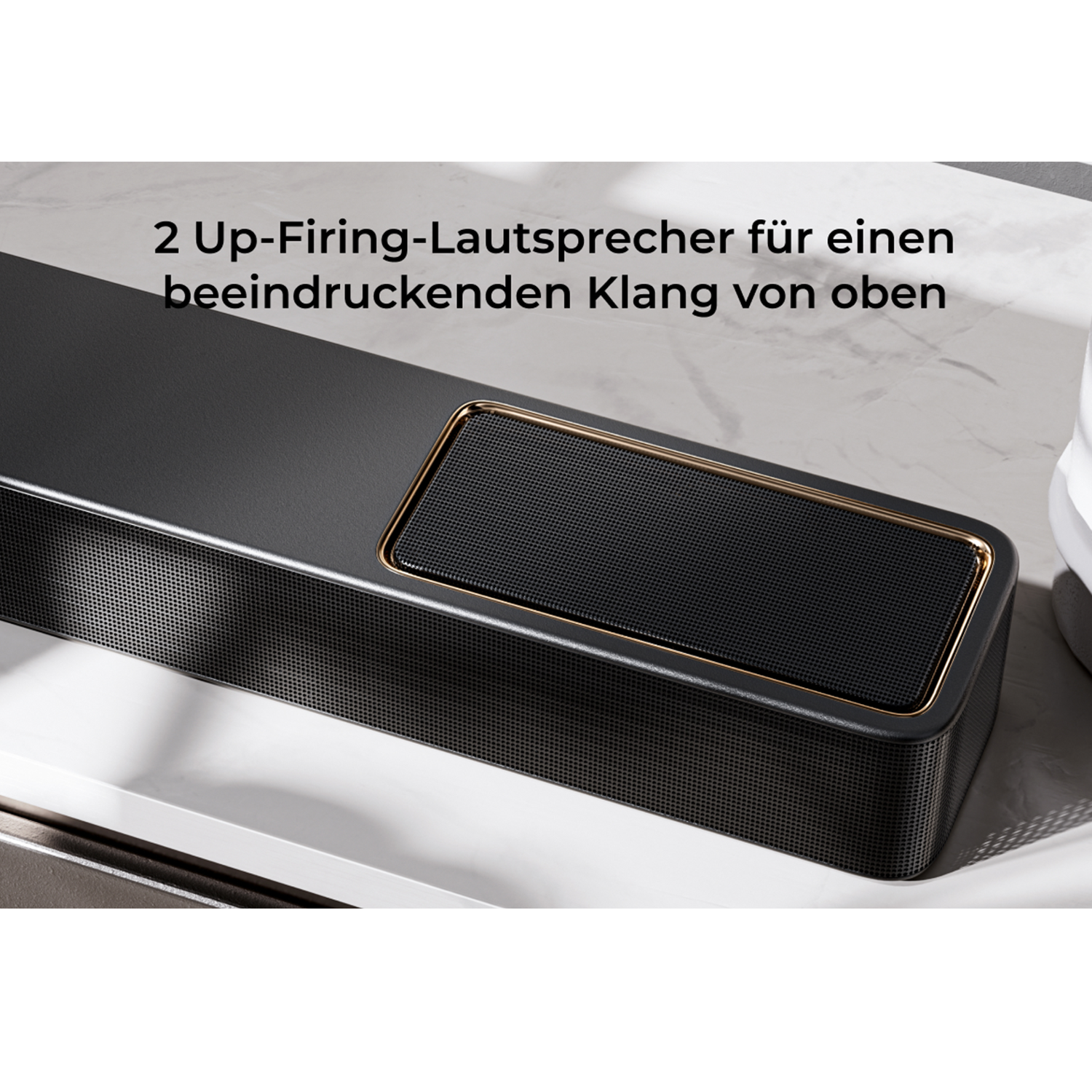 Czarny głośnik ze złotym wykończeniem i perforowaną kratką.