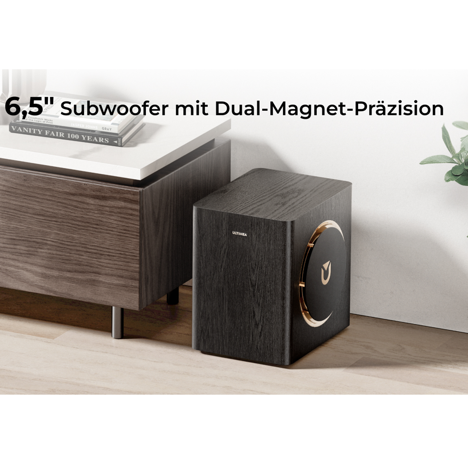 Ein schwarzer Subwoofer mit goldenen Akzenten steht neben einem Schrank.