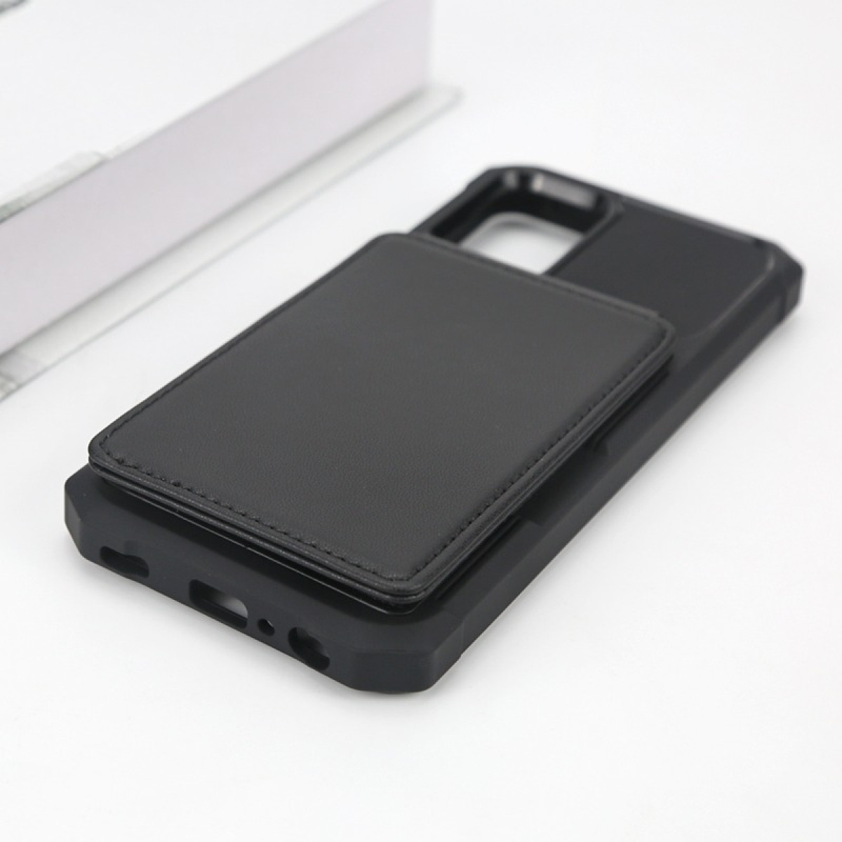 Custodia nera per telefono con porta carte in pelle su sfondo bianco.