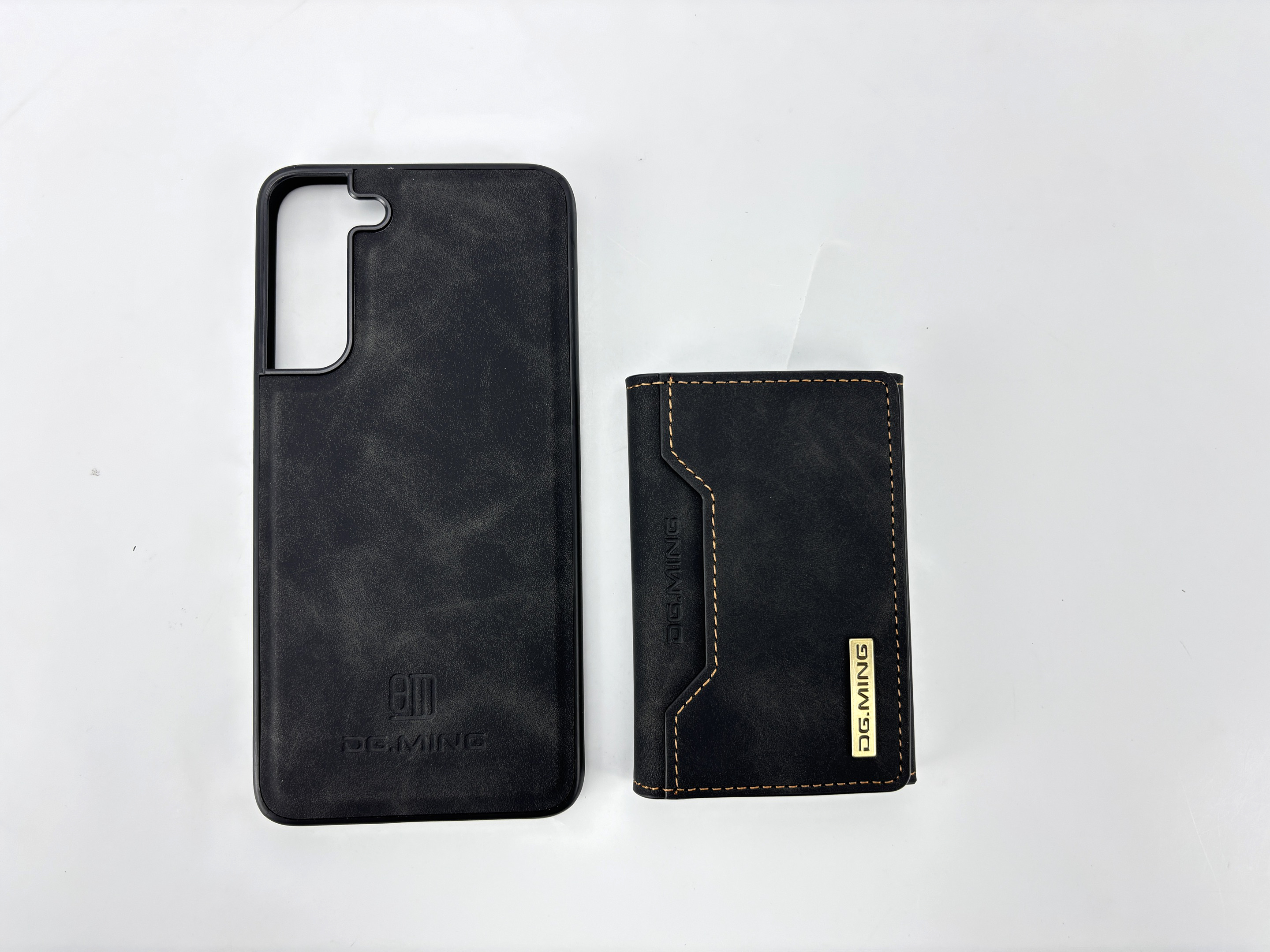 Schwarze Handyhülle und Brieftasche aus Leder mit Nähten auf weißem Hintergrund.