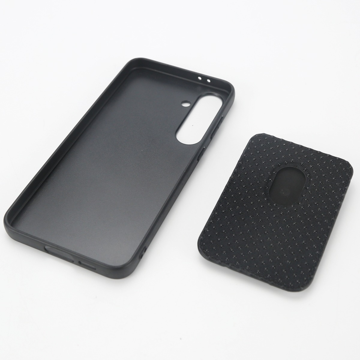 Una custodia nera per smartphone e una cover posteriore nera giacciono una accanto all'altra.