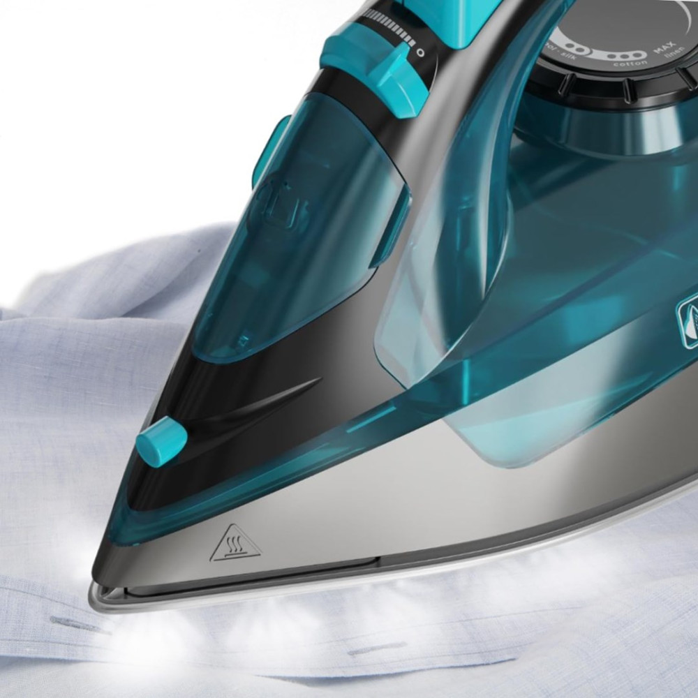 Zbliżenie żelazka parowego z turkusowymi i czarnymi akcentami, prasującego jasnoniebieską koszulę.