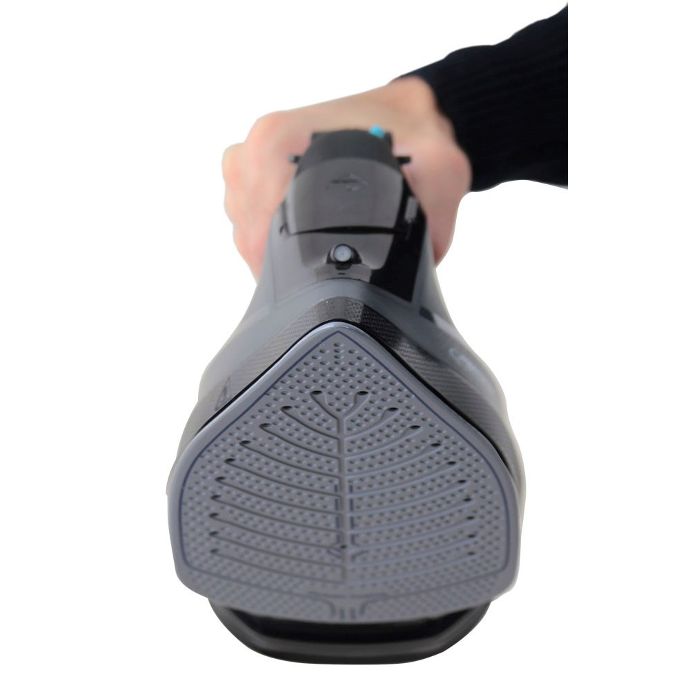 Dłoń trzyma żelazko z szarą stopą z wzorem liścia.