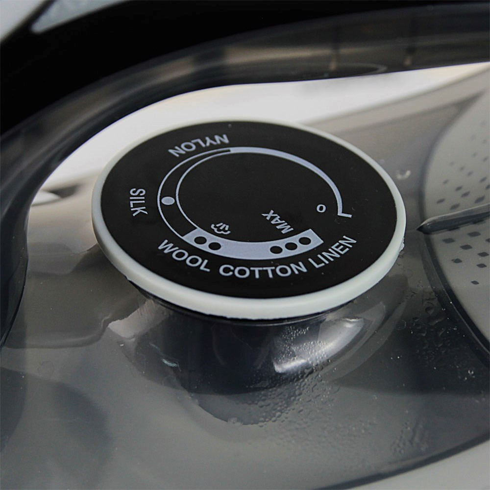 Zbliżenie czarnego pokrętła z ustawieniami tkaniny: Jedwab, Nylon, Wełna, Bawełna, Len.