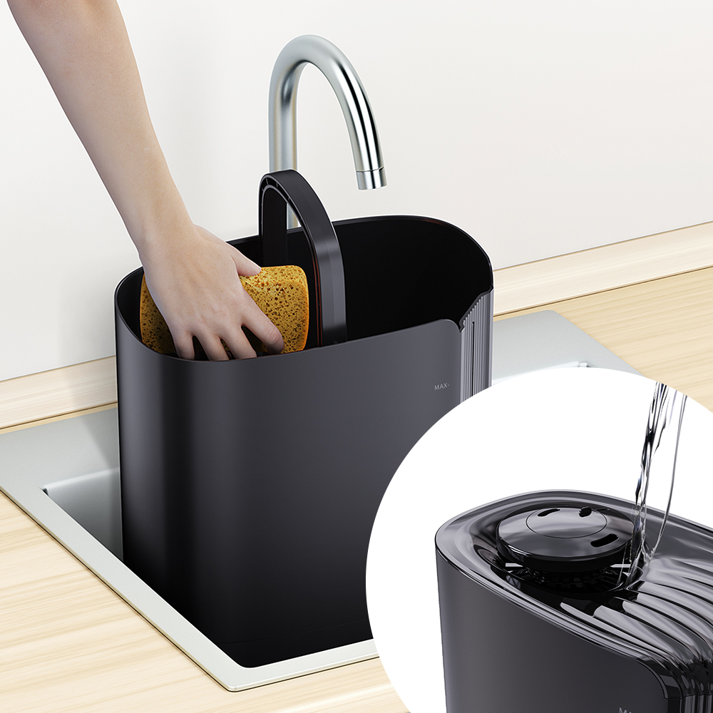 Ręka trzyma gąbkę w czarnym pojemniku pod kranem.