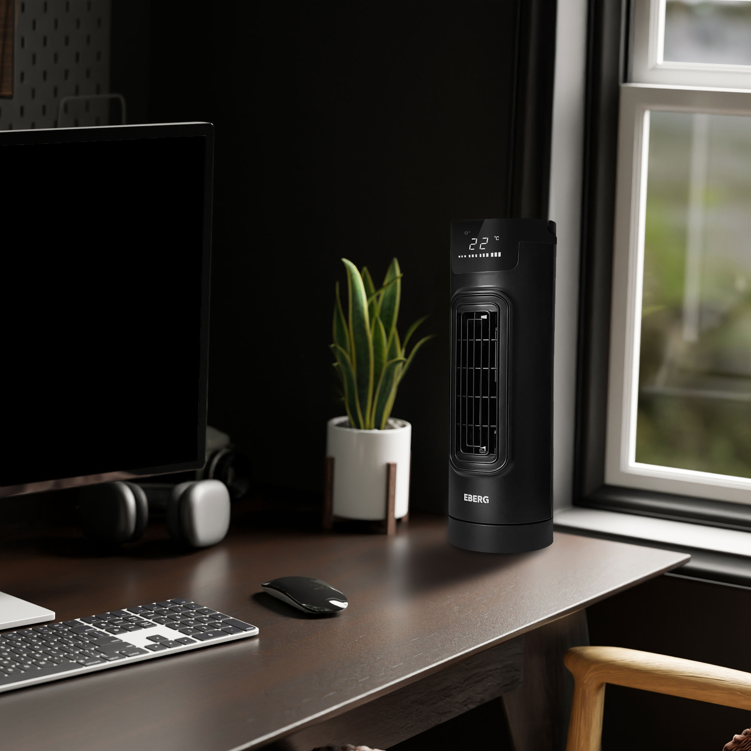 Czarny wentylator wieżowy na biurku ze sprzętem komputerowym i rośliną.