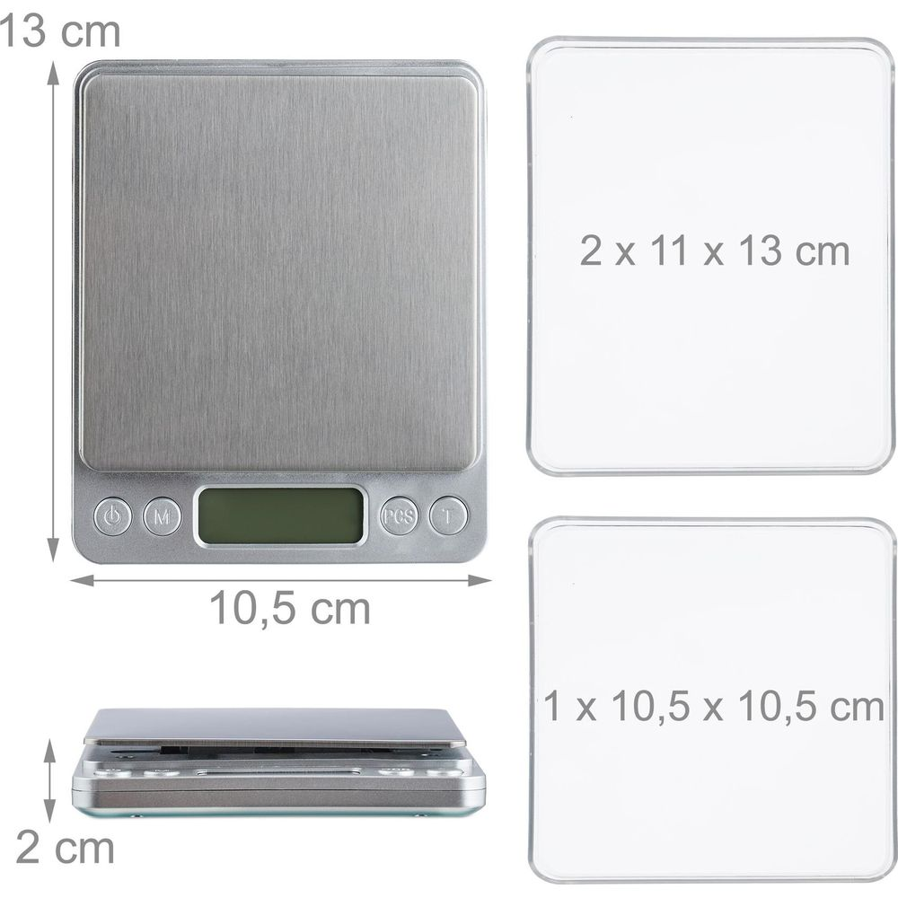 Bilancia argentata con display LCD, accanto due vassoi trasparenti.