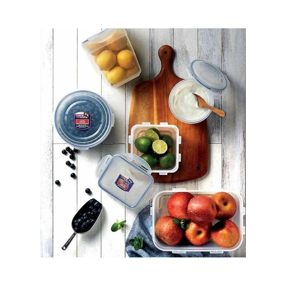Contenitori trasparenti per alimenti con limoni, lime, mirtilli, mele e yogurt su tagliere di legno.