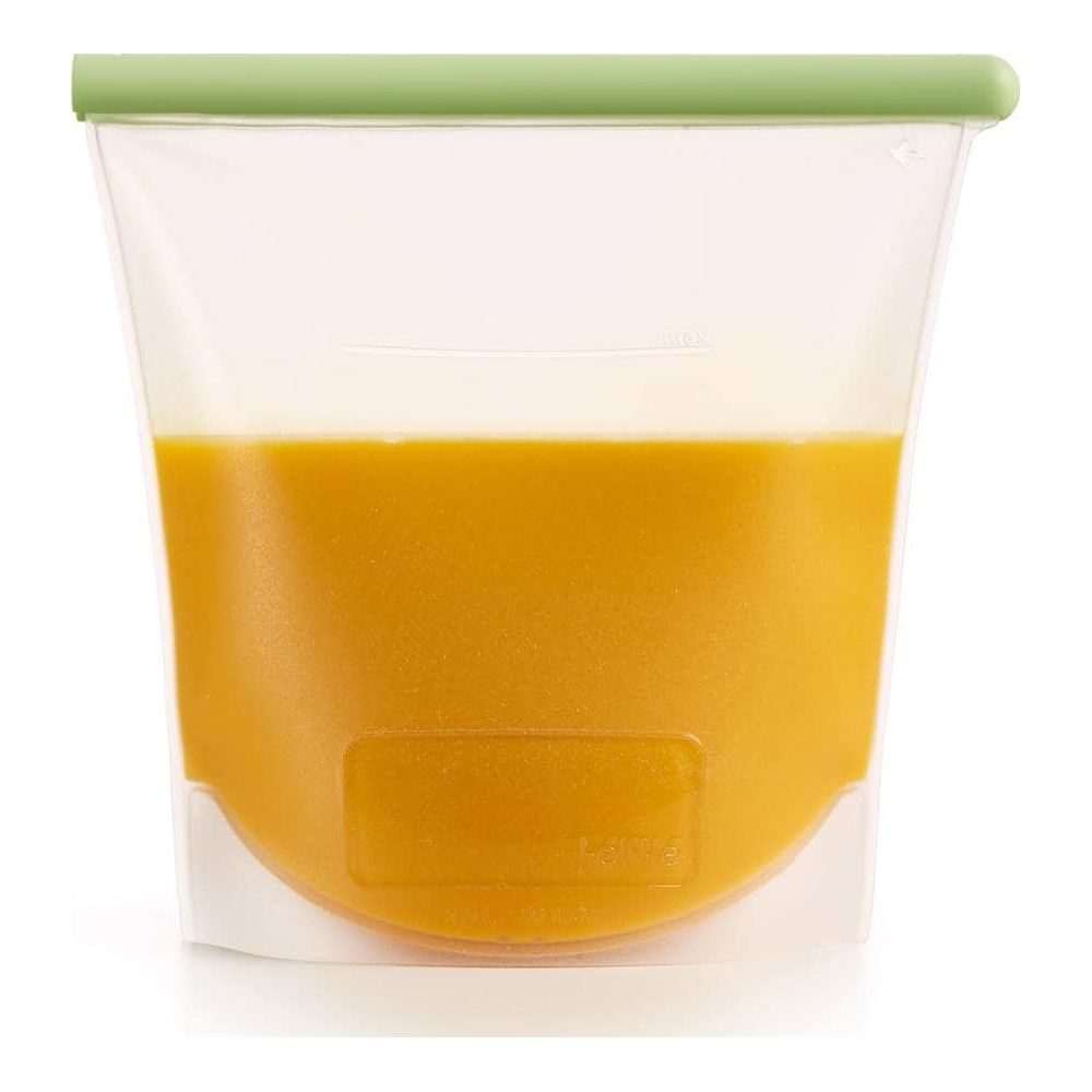Ein durchsichtiger Beutel mit grünem Verschluss, gefüllt mit orangem Saft.