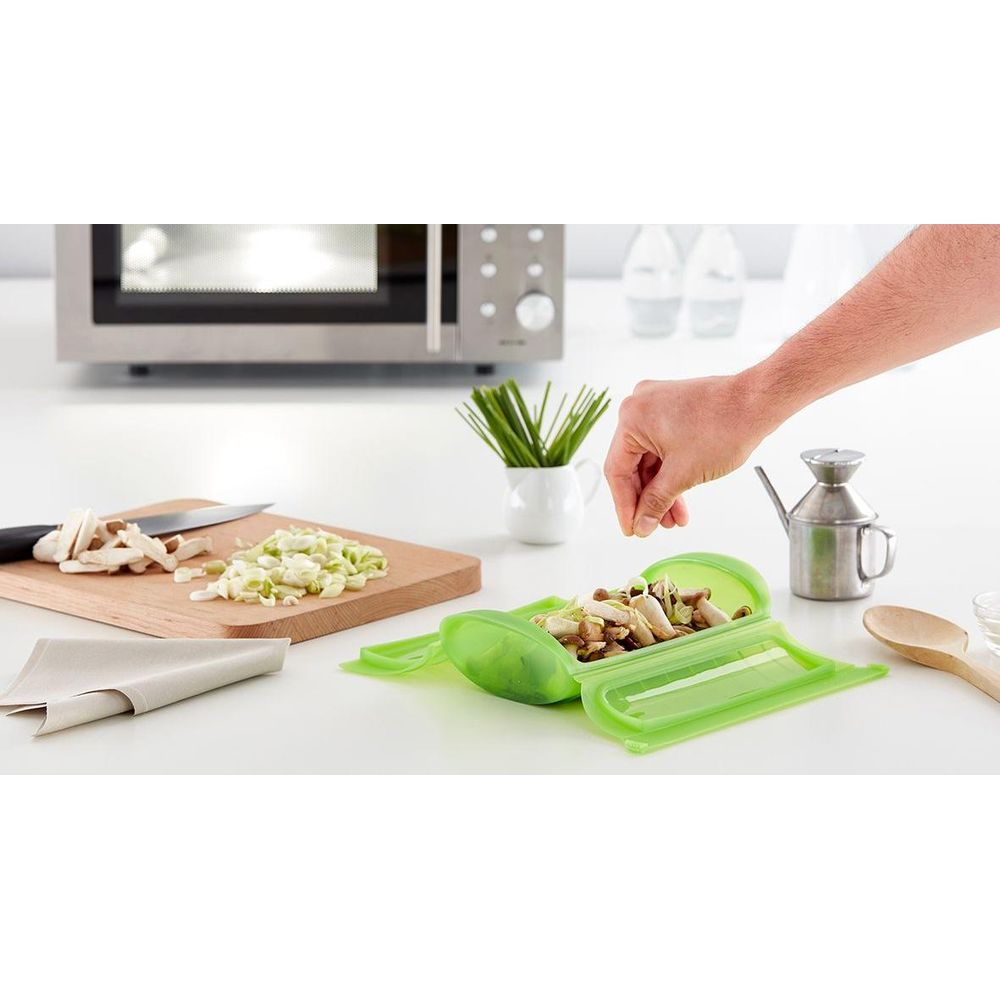 Grüner Behälter mit Pilzen, geschnittene Zwiebeln und Pilze auf Brett.
