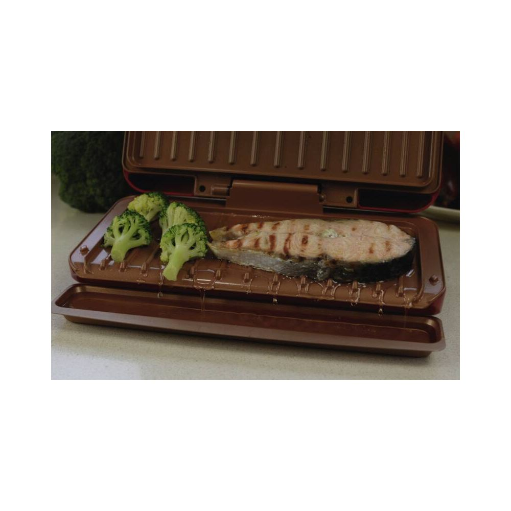 Una bistecca di salmone e broccoli vengono cotti in una griglia marrone.