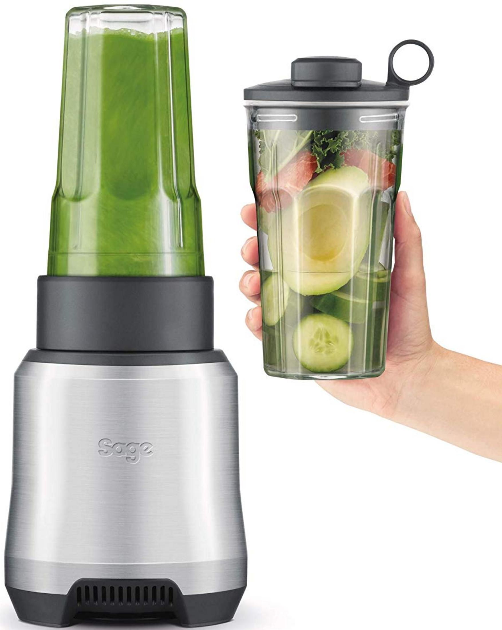 Base argento per frullatore Sage con frullato verde nel bicchiere. Mano tiene bicchiere con avocado, cetriolo, cavolo riccio.