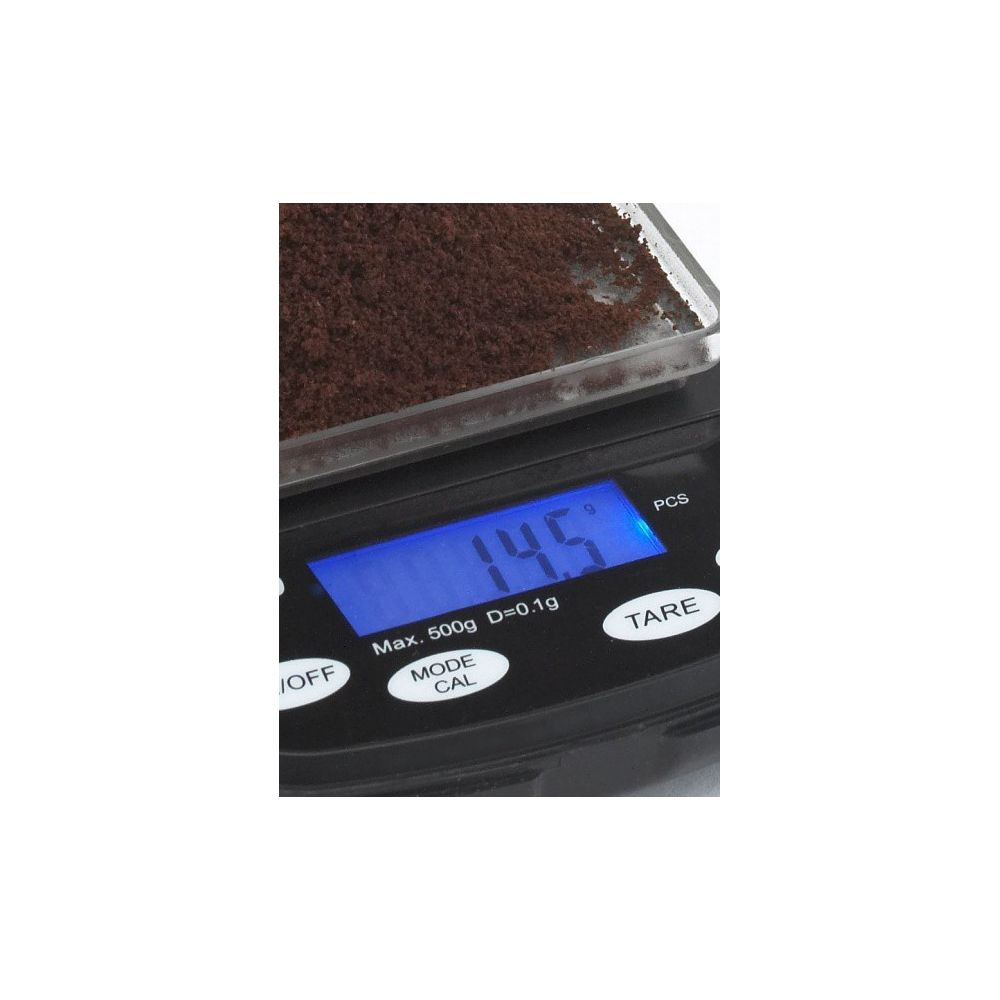 Une balance numérique affiche 14,5 grammes de café moulu sur la plateforme.