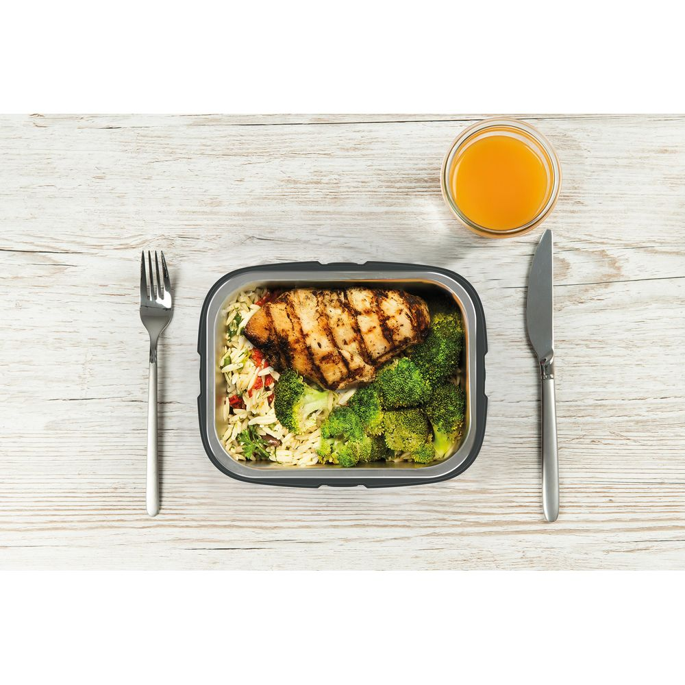 Gegrilltes Hähnchen mit Reis und Brokkoli in einem Behälter, daneben ein Glas Saft.