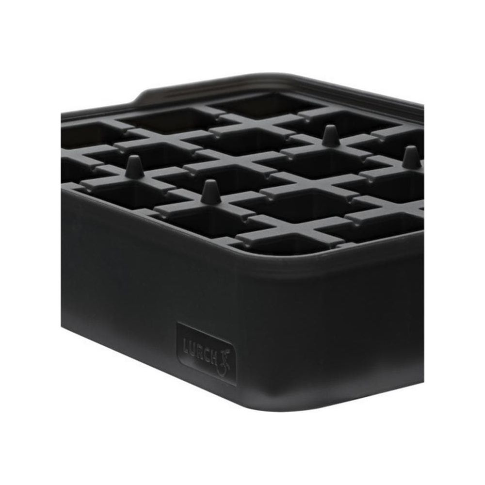 Una vaschetta per cubetti di ghiaccio nera con griglia e pioli.