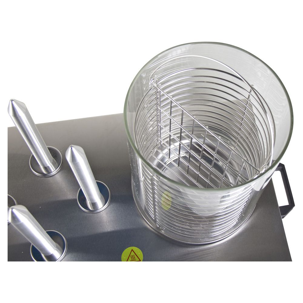 Poignées métalliques sur une surface métallique lisse à côté d'un récipient en verre avec panier en fil.