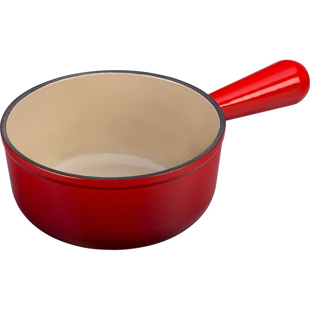 Rote gusseiserne Schüssel mit langem Griff auf weißem Hintergrund.