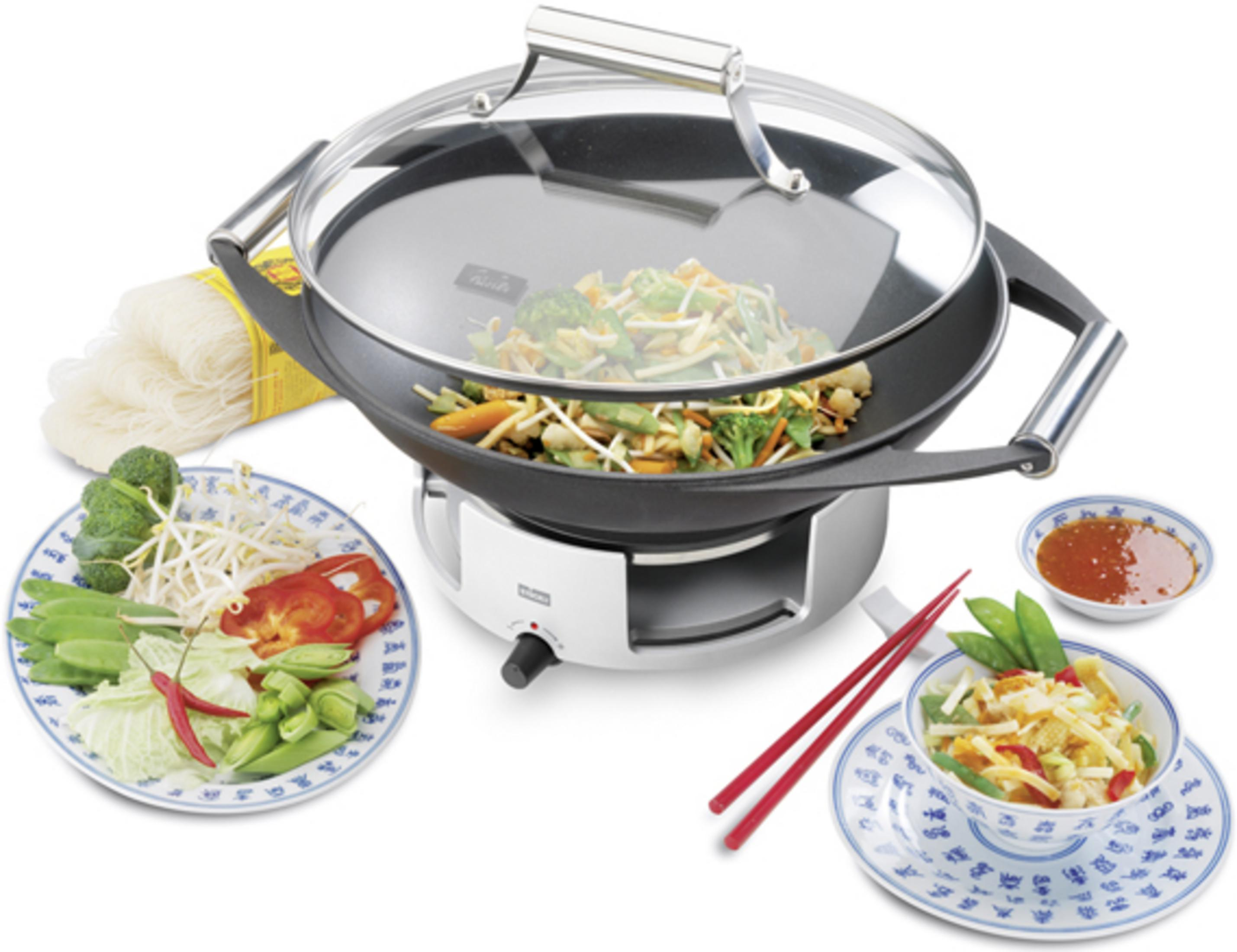 Ein Wok mit gebratenem Gemüse, Reisnudeln, Zutaten und Dip.