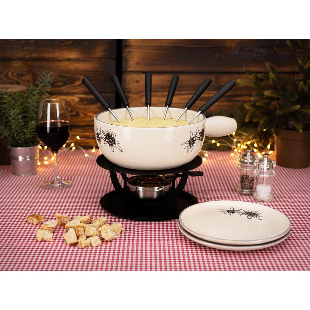 Ein Käsefondue-Set mit Brotstücken, Wein und Gewürzstreuern auf kariertem Tisch.