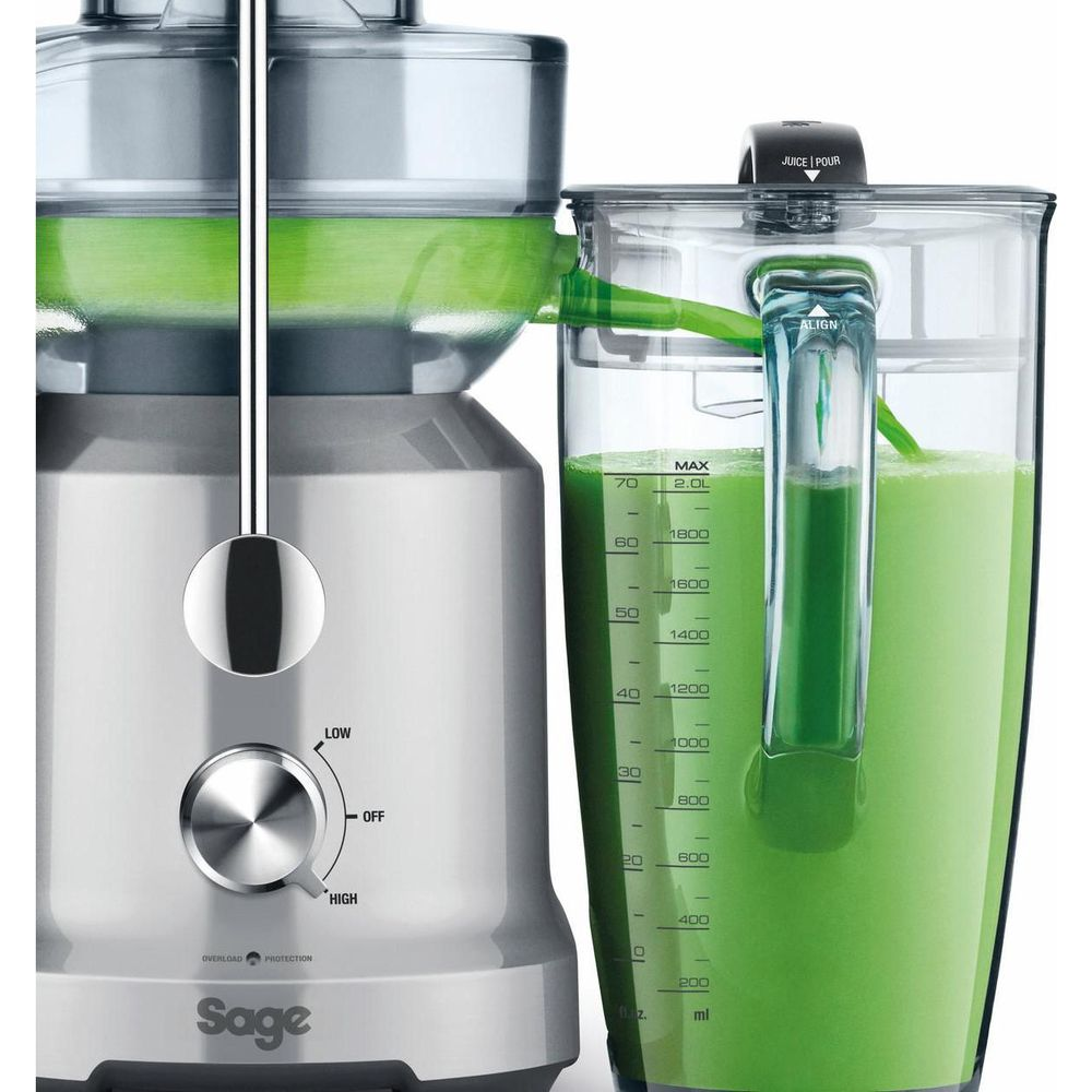 Un estrattore argento con caraffa piena di succo verde. La caraffa è quasi piena.