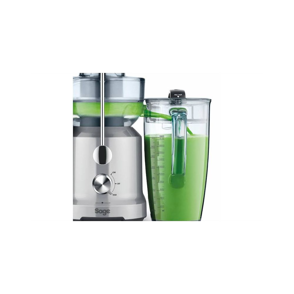 Spremiagrumi argento con caraffa piena di succo verde.
