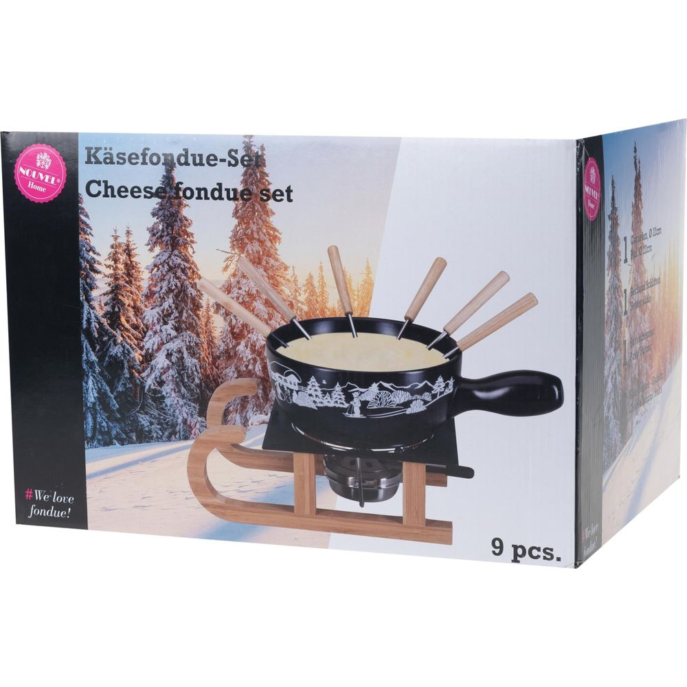 Käsefondue-Set mit Fondue-Topf, Rechaud und Holzlöffeln auf einer Schlitten-Requisite.