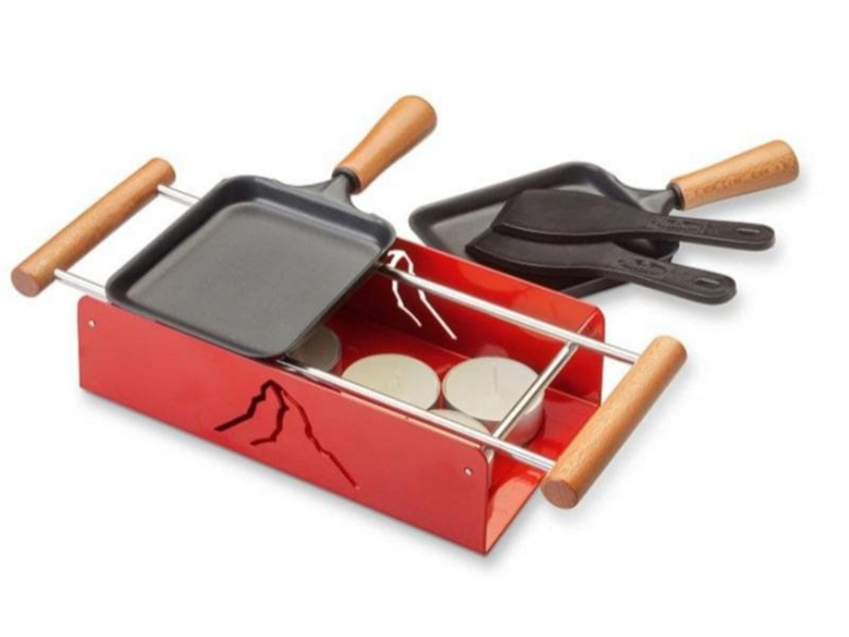 Un set raclette rosso con due padelle e lumini.
