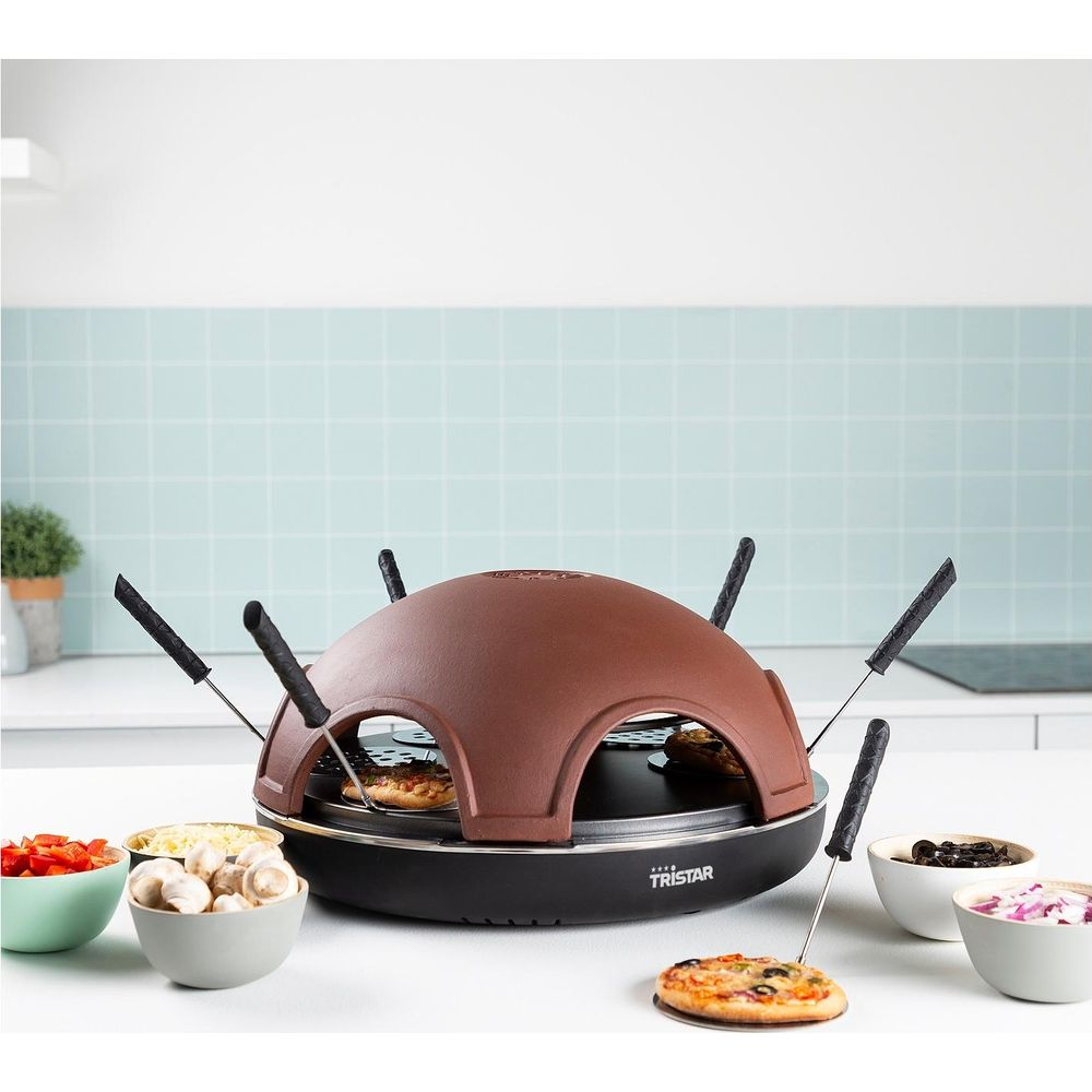 Un four à pizza marron avec quatre mini pizzas et des bols d'ingrédients.