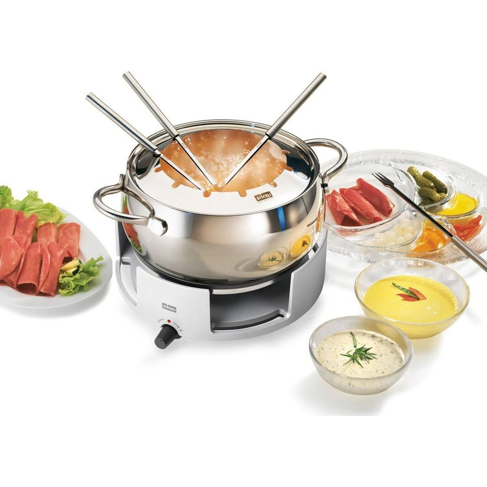 Ein Fondue-Set mit Topf, Gabeln, Fleisch und Soßen