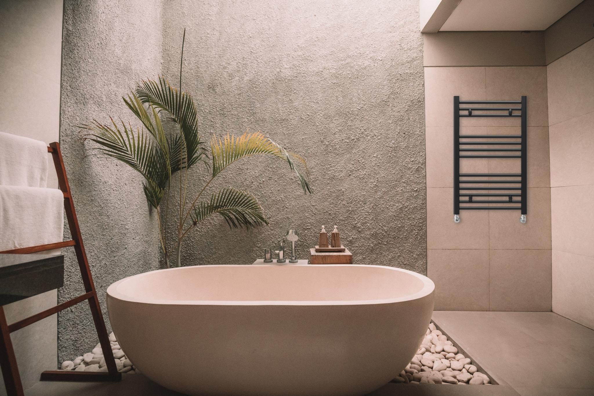 Un baño moderno con bañera exenta, escalera con toallas y toallero.