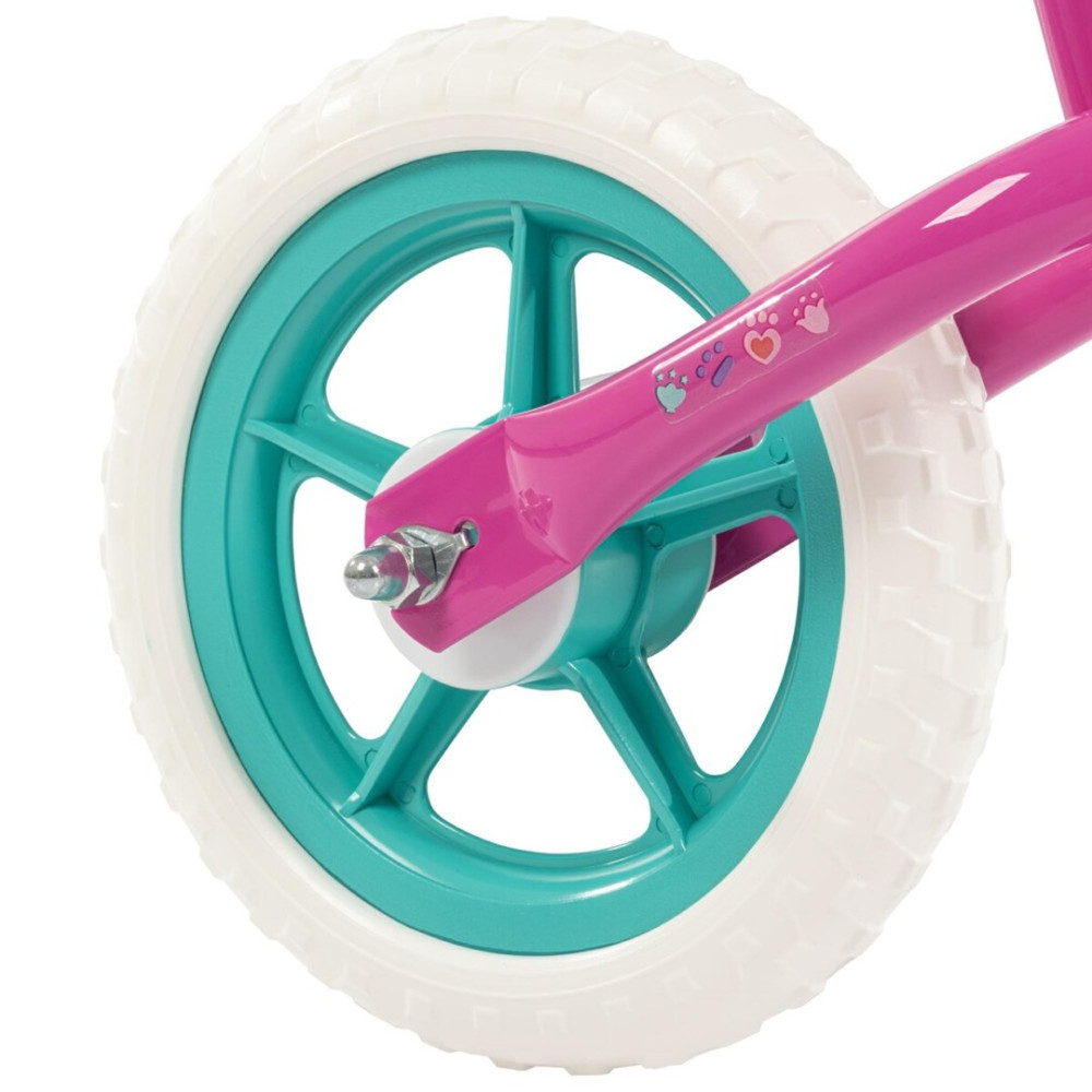 Zbliżenie na różową ramę roweru z białym bieżnikiem i turkusowym kołem. Na ramie odciski łap.