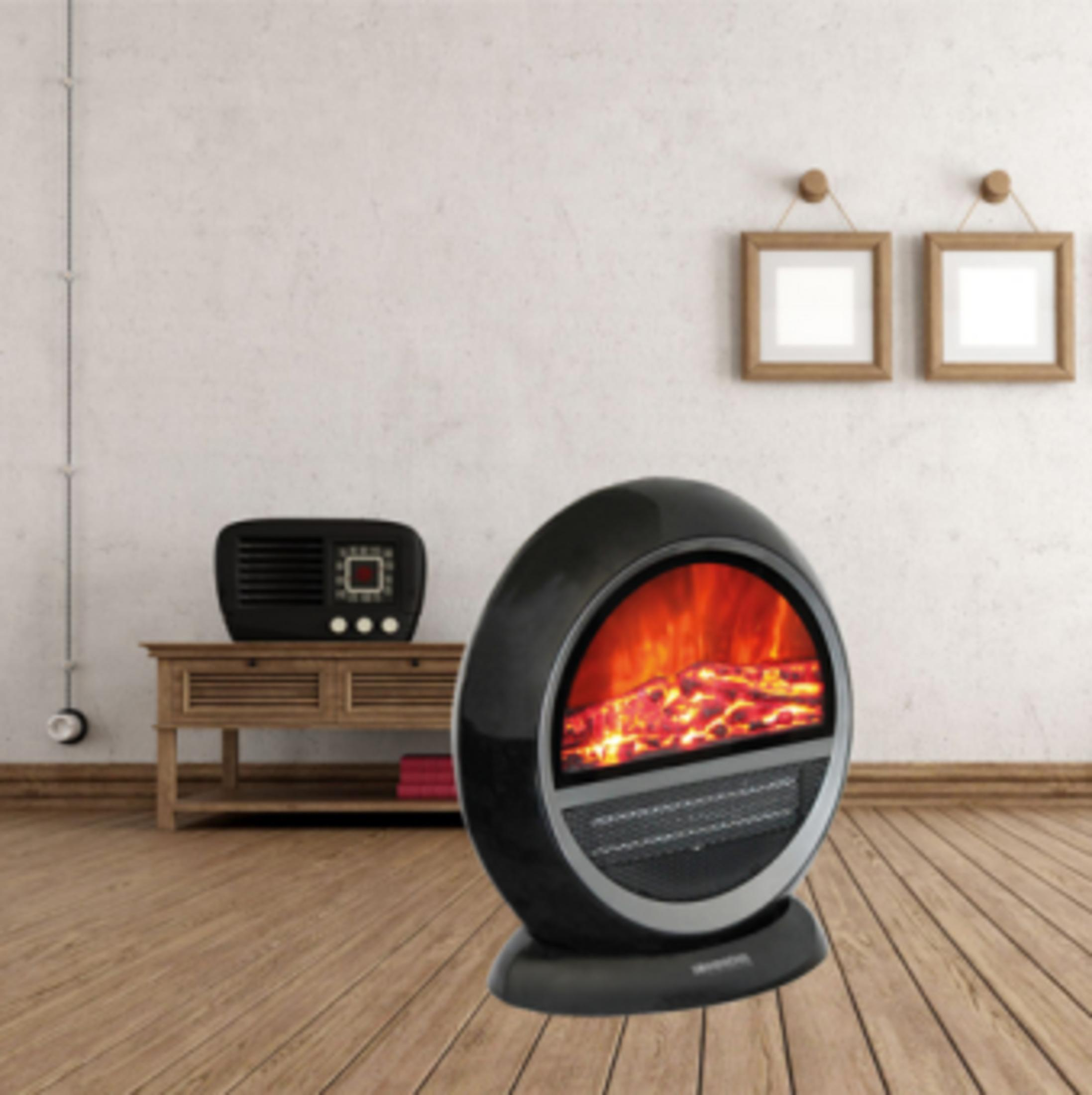 Une cheminée électrique ovale noire avec effet de flamme sur un plancher en bois.