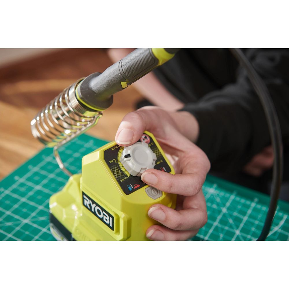 Hand stellt Temperaturregler an gelber Ryobi-Lötstation ein.