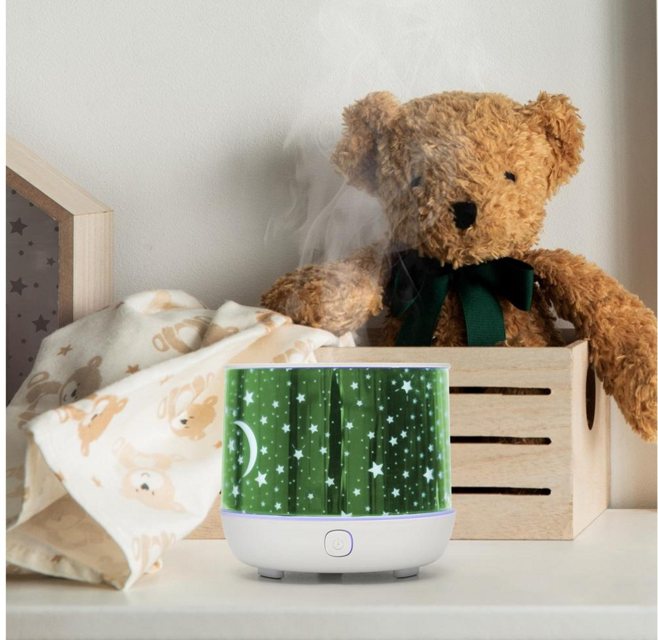 Un diffusore con motivo a stelle, orsacchiotto, scatola di legno e tessuto con stampa di orso.