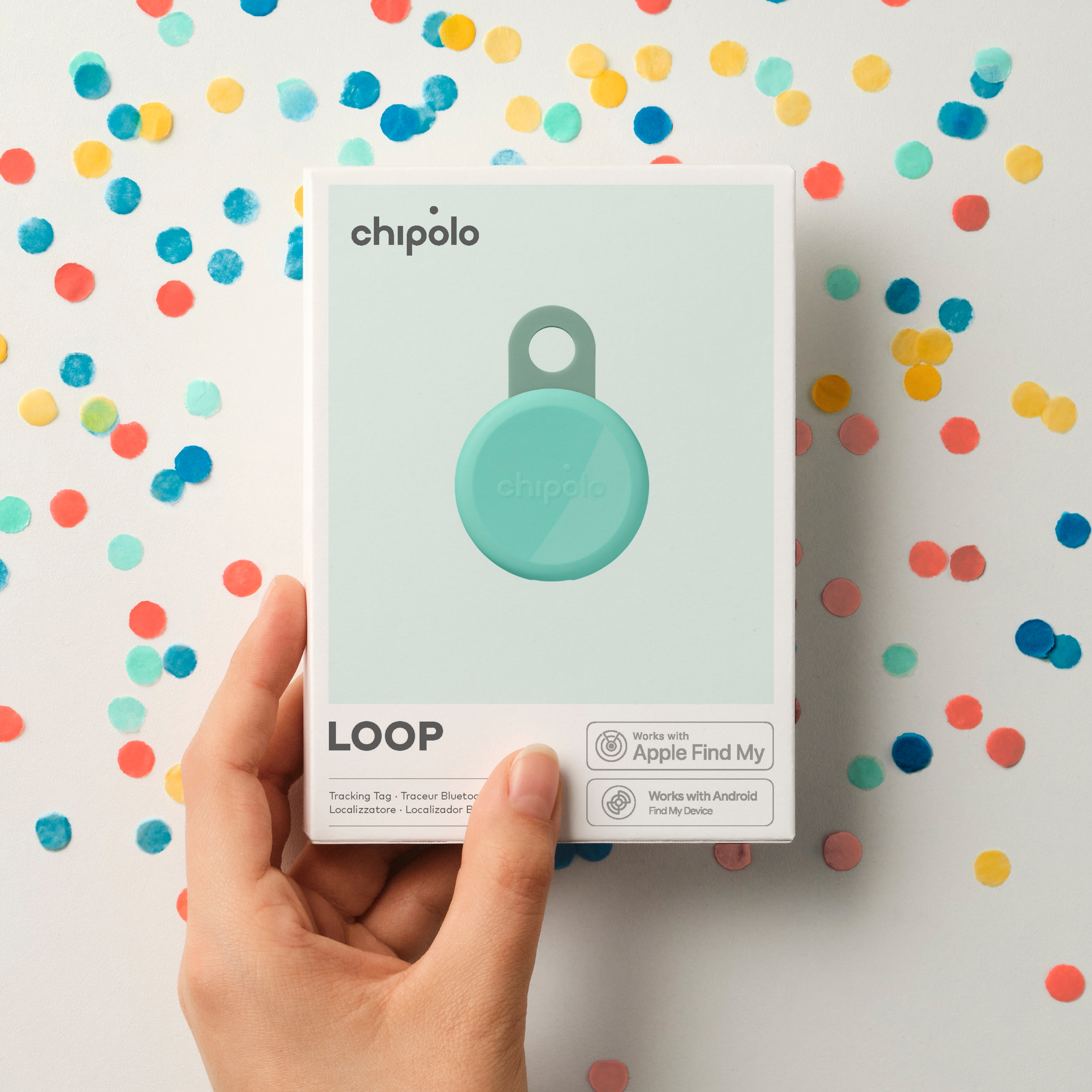 Chipolo LOOP packaging with Chipolo tracker, held by a hand.
